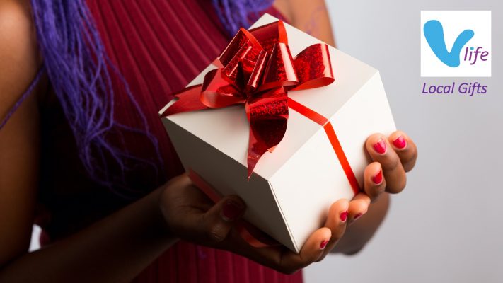 Black woman holding wrapped present with red bow, local gifts