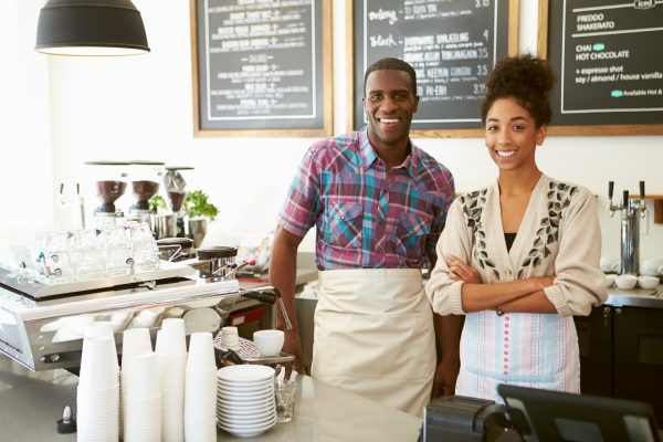 Small business owners in their cafe. vLife Blog The Many Benefits of Buying Local