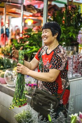 Chinese Business owner smiling and preparing products in shop. vLife Blog: Supporting local BIPOC businesses