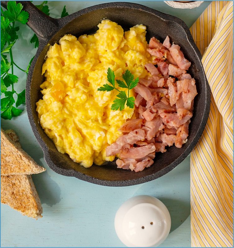 Scrambled eggs and ham in cast iron skillet. vStore Image Maritime Inn Antigonish Free Hot Breakfast Mar 2023